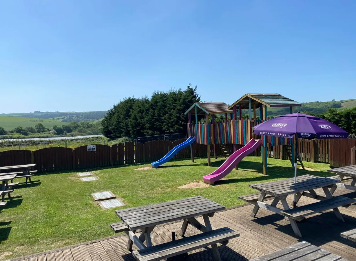 Outdoor decking with picnic benches, children's play area and Cornish countryside views at The Windy Ridge